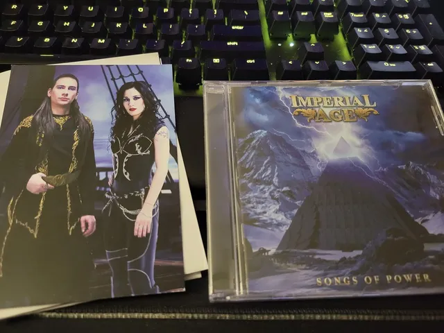 Songs of Power CD and band card on a desk